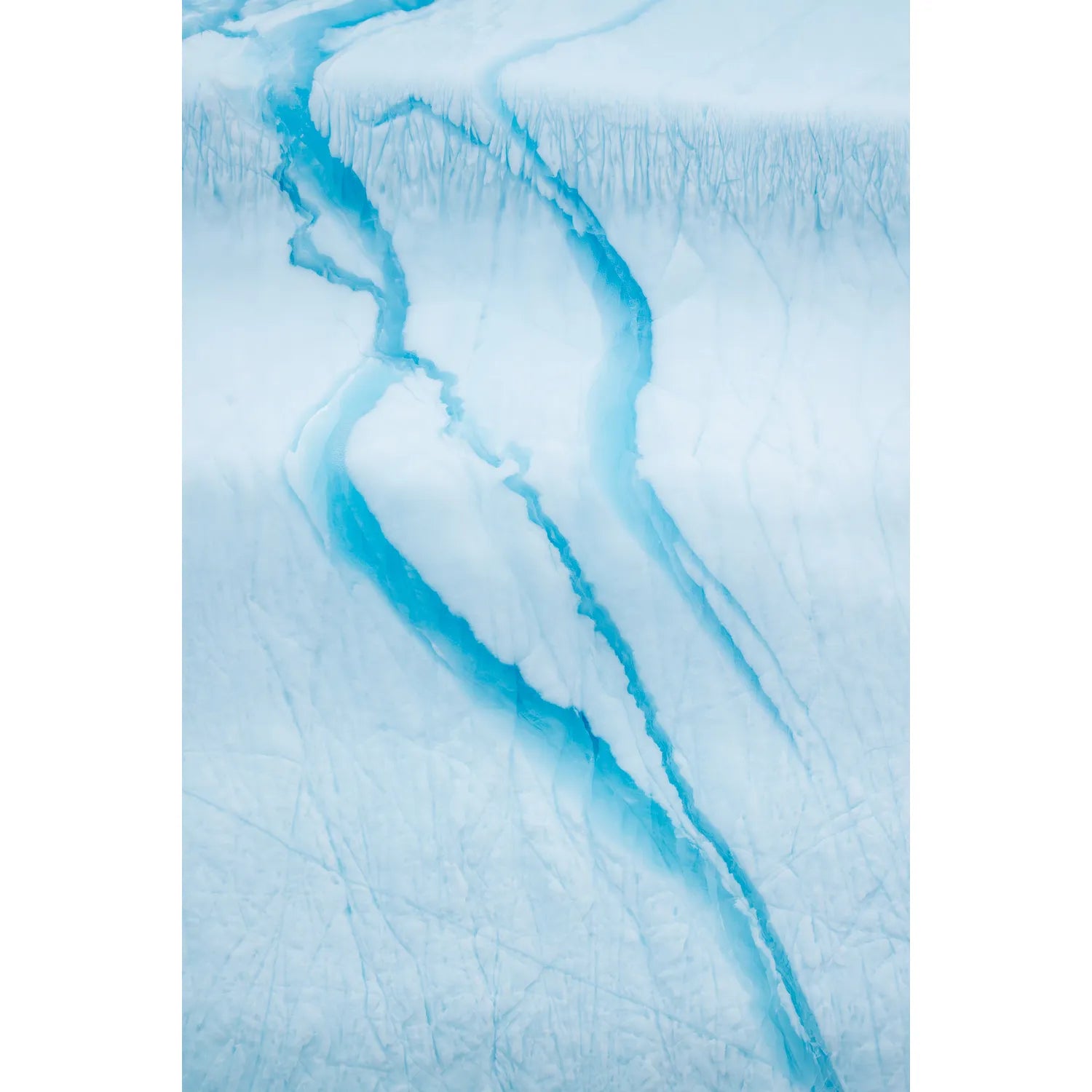 Turquoise meltwater channels carving through the white surface of an iceberg in Scoresby Sound, Greenland, fine art landscape photograph by Peter Cox