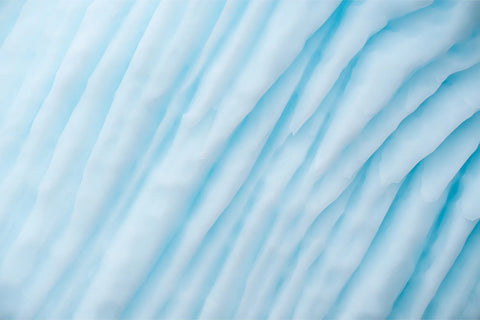 Close-up abstract of glacial ice showing flowing blue ridges and channels in Scoresby Sound, Greenland, fine art landscape photograph by Peter Cox