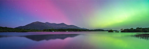 Aurora borealis in vivid green and purple over Lough Leane with the Reeks reflected in still water, Killarney, Kerry