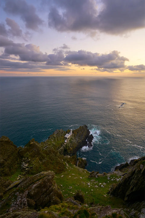 Skellig Michael lighthouse at twilight with a slender new moon and golden Atlantic horizon, Kerry