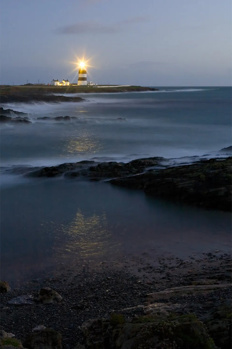 Hook Lighthouse beam reflecting across calm waters at dusk, Co. Wexford — fine art landscape photograph by Peter Cox