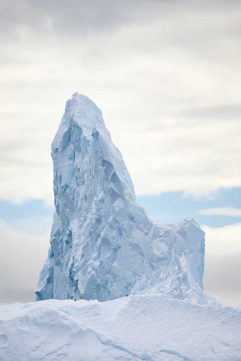 Towering spire-shaped iceberg with Antarctic terns perched on its ridge near Cuverville Island, Antarctic Peninsula — fine art landscape photograph by Peter Cox