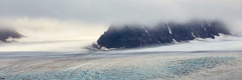 Panoramic glacier surface with mist-shrouded mountains and blue crevasses in Svalbard, fine art landscape photograph by Peter Cox