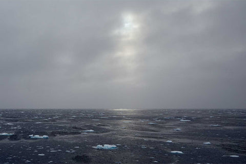 Hazy sun glowing through clouds over floating ice in the Barents Sea — fine art landscape photograph by Peter Cox