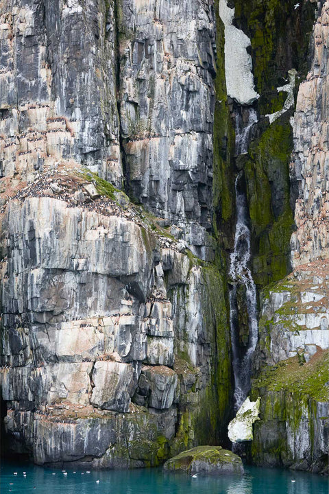 Waterfall cascading through a cliff crevasse at Alkefjellet, Svalbard, fine art landscape photograph by Peter Cox