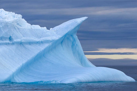 Sculpted blue iceberg with curved forms in Arctic waters, Svalbard — fine art landscape photograph by Peter Cox