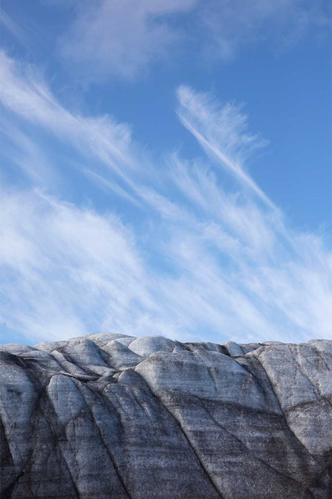 Ridged dark glacier surface beneath cirrus clouds and blue sky at Isbukta, Svalbard, fine art landscape photograph by Peter Cox