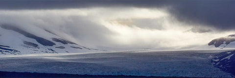 Dramatic light and shadow across the Isbukta glacier panorama with darkened clouds in Svalbard, fine art landscape photograph by Peter Cox