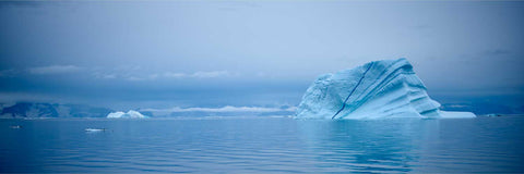 Iceberg with blue veins drifting in calm misty waters, eastern Greenland — fine art landscape photograph by Peter Cox