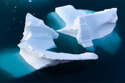 Bowl-shaped icebergs floating in deep blue waters near Red Island in Scoresby Sound, Greenland — fine art landscape photograph by Peter Cox