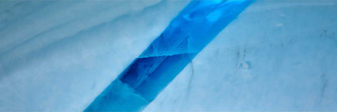 Clear blue meltwater channel cutting through pristine iceberg ice in Greenland — fine art landscape photograph by Peter Cox
