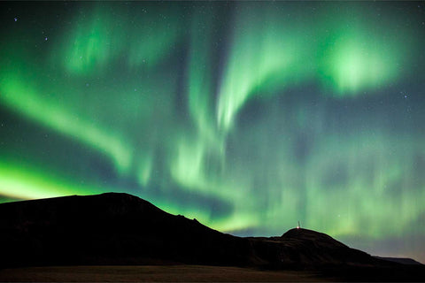 Aurora borealis over mountain silhouette near Vik, Iceland — fine art landscape photograph by Peter Cox
