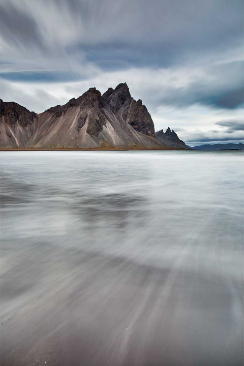 Vestrahorn mountain rising from the Stokksnes shoreline with tide sweeping across black volcanic sand, Iceland