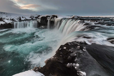 Godafoss waterfall in winter with ice formations and golden sunrise light, northern Iceland — fine art landscape photograph by Peter Cox