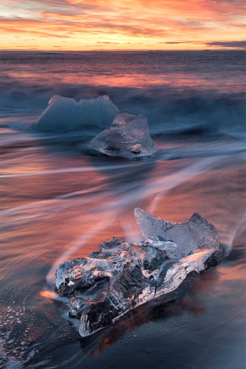 Ice on black sand beach at sunrise with long exposure waves, Breidamerkursandur, Iceland — fine art landscape photograph by Peter Cox