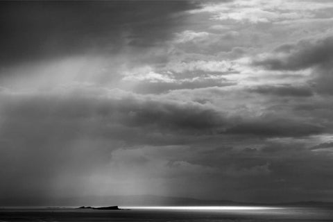Black and white photograph of a rainstorm sweeping across the Skerries islands off the North Antrim coast near Portrush