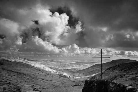 Black and white view from the Priest's Leap mountain pass looking south to Bantry Bay with a cross silhouetted against cloud