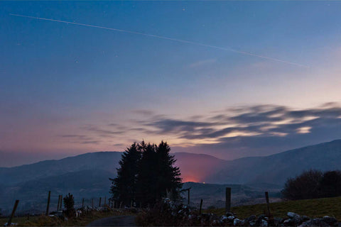 Light trail of the International Space Station and Shuttle Discovery streaking over the hills of Gougane Barra at night