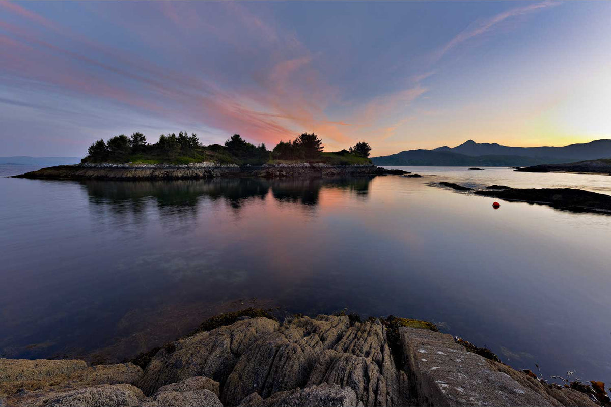 Illauncreeveen island in Glengarriff harbour at sunset, pink and orange cloud above the water with the Sugar Loaf and the Caha mountains in silhouette behind, Co. Cork — fine art landscape photograph by Peter Cox