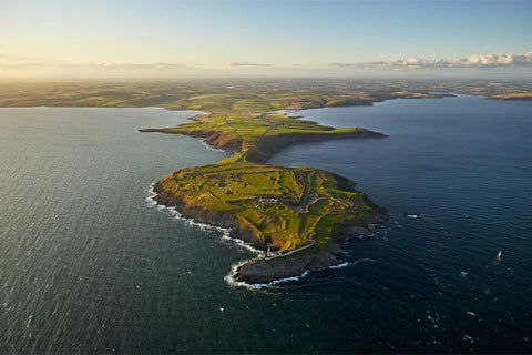 Aerial view of the Old Head of Kinsale at sunset showing the lighthouse, golf course and dramatic sea cliffs, County Cork