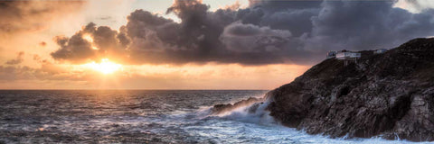 Mizen Head lighthouse and signal station on rugged cliffs at sunset with heavy Atlantic swell, Cork