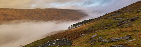 Morning mist swirling through the isolated Cum na Leime valley near Bantry, Cork with the Priest's Leap ridge wreathed in cloud