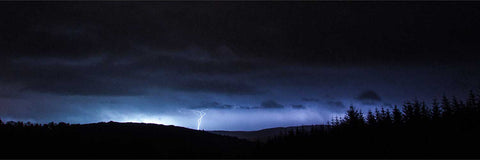 Lightning bolt illuminating dark clouds over the landscape at Ballingeary, County Cork