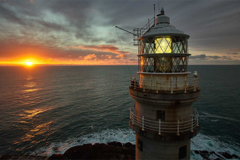 The Fastnet Lighthouse lantern glowing as the first rays of sunrise strike it on a spring morning off West Cork