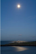 Moonlight reflecting on the sea near the Muglins lighthouse off Dalkey Island, Dublin, with the Kish light on the horizon