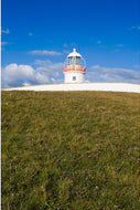 St. John's Point Lighthouse standing on the headland on a bright spring day with green grass, Donegal