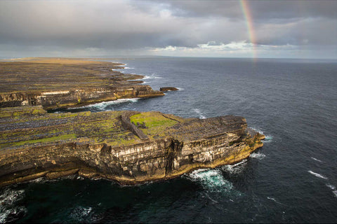 Aerial view of Black Fort ruins on Inis Mor cliffs with rainbow, Aran Islands, Co. Galway, Ireland — fine art aerial photograph by Peter Cox