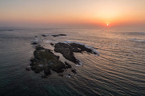 Aerial view of Inisheeshan islet off Connemara at sunset with Slyne Head lighthouses in the distance, Co. Galway — fine art aerial photograph by Peter Cox