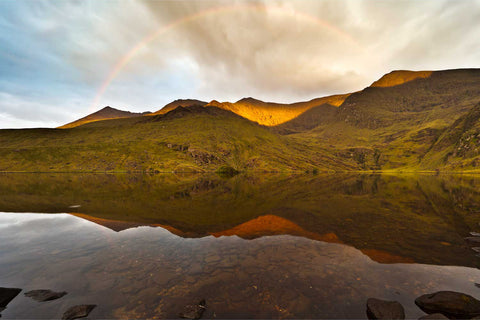 Rainbow arching over the jagged peaks of the Macgillycuddy's Reeks at sunset, seen from Lough Callee in Kerry
