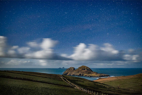 Moonlit night view of Puffin Island and the Skelligs off the Kerry coast with illuminated foreground under clearing clouds