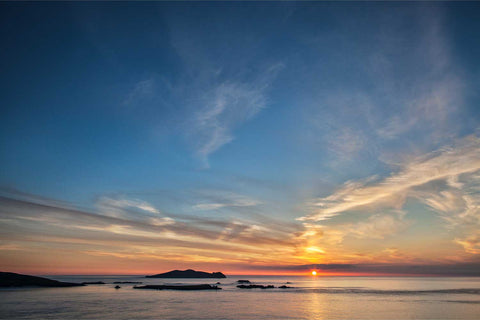 The Sleeping Giant island silhouetted at sunset off the Dingle Peninsula with warm light on the Atlantic horizon