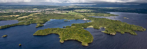 Aerial view of Ross Castle and Ross Island on Lough Leane with Killarney town in the background on a blustery summer day