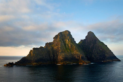 Skellig Michael's two rugged peaks bathed in soft golden light seen from the north, rising from the Atlantic off Kerry