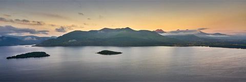 Aerial sunrise view over Lough Leane and Inishfallen Island with Macgillycuddy's Reeks in golden morning light, Killarney, Kerry