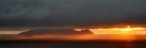 Panoramic sunset view of the Sleeping Giant off Dingle with golden light on the ocean and mountains beyond