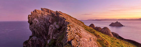 Panoramic sunrise view of the Skellig Michael monastery sheltering beneath the jagged North Peak ridge with the Atlantic beyond