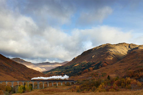 Steam train crossing Glenfinnan Viaduct surrounded by autumn foliage, Scottish Highlands — fine art landscape photograph by Peter Cox