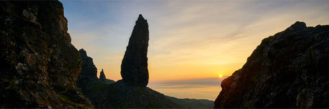 The Old Man of Storr rock formation silhouetted against a warm sunrise on the Isle of Skye, Scotland