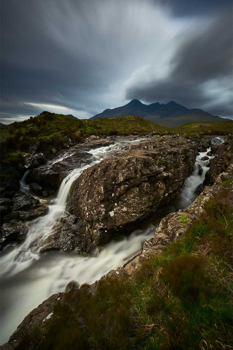 The Black Cuillin mountains under brooding skies with the river at Sligachan rushing over rocks on the Isle of Skye