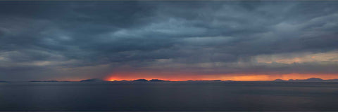 Vivid sunset over the Outer Hebrides seen from the Isle of Skye, Scotland, with rich reds and oranges on the horizon