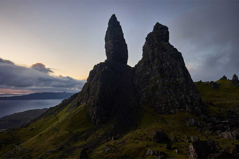 The Old Man of Storr rock formation at dawn with its dark peaks against a softly glowing sky, Isle of Skye, Scotland
