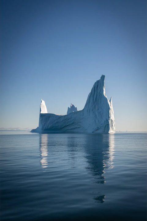 Jagged iceberg with reflection in Scoresby Sound, Greenland, fine art landscape photograph by Peter Cox