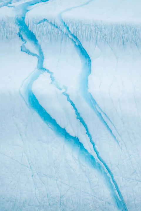 Turquoise meltwater channels carving through the white surface of an iceberg in Scoresby Sound, Greenland, fine art landscape photograph by Peter Cox