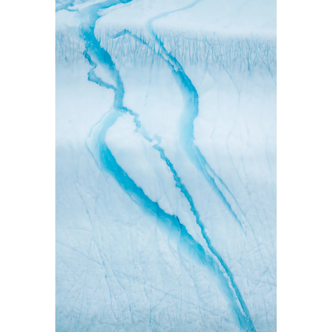 Turquoise meltwater channels carving through the white surface of an iceberg in Scoresby Sound, Greenland, fine art landscape photograph by Peter Cox