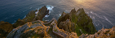 Evening light over Skellig Michael's South Peak showing ancient stone terraces, lighthouse, and the Atlantic beyond