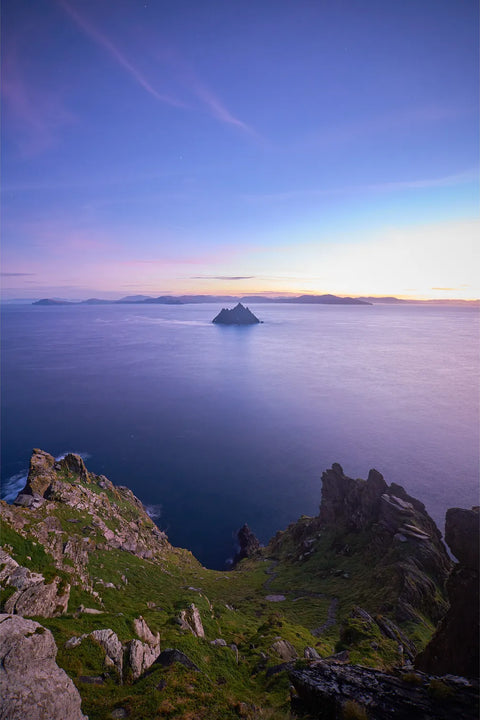 Pre-dawn violet and pink light over the East Steps of Skellig Michael with Little Skellig silhouetted on a still sea